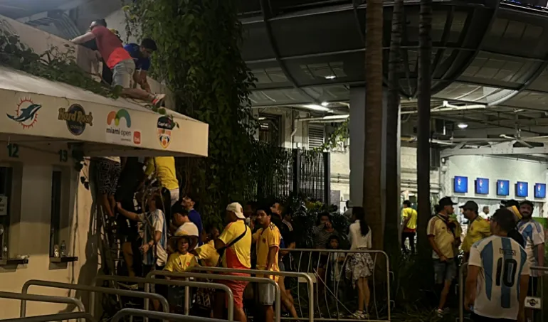 Fans use barricades as ladders to climb into the Hard Rock Stadium for the Copa America final between Argentina and Colombia in Miami Garden 